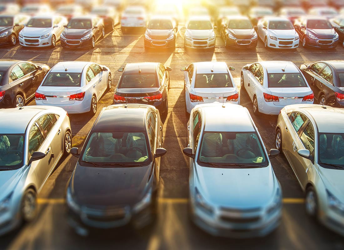 Business Auto Insurance - Fleet of Cars Sitting in the Parking Lot with the Sun Behind